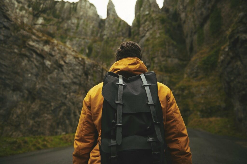 Wandern was gehört in den Rucksack Mann vor Gebirge