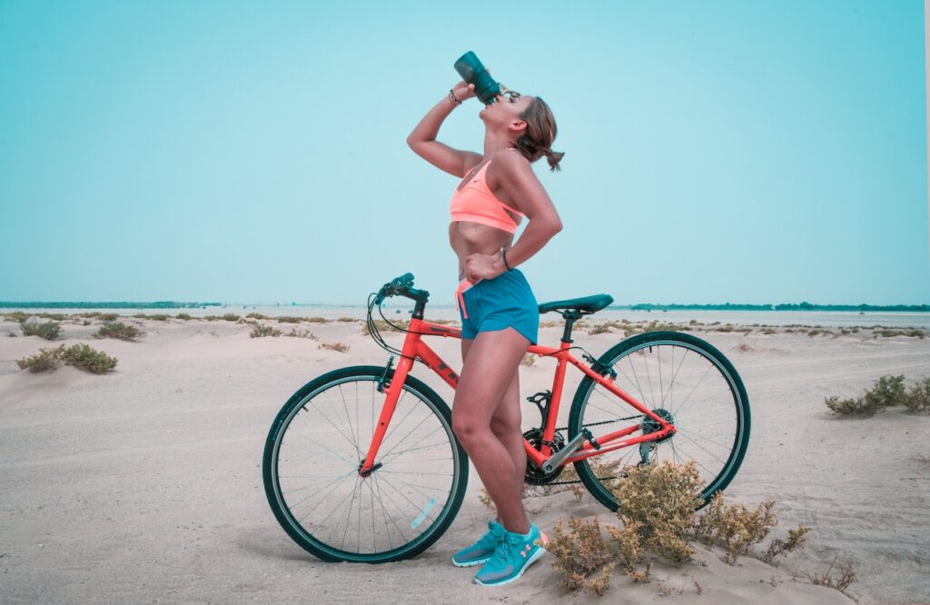 Frau Wasser trinken Fahrradtour Wandern Sauberes Trinkwasser auf Tour